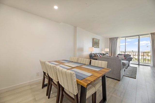 dining area featuring light wood-type flooring, baseboards, floor to ceiling windows, and recessed lighting