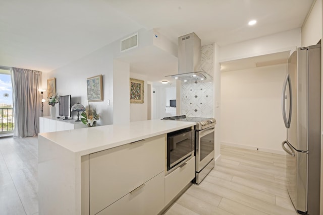 kitchen featuring visible vents, modern cabinets, appliances with stainless steel finishes, extractor fan, and light countertops