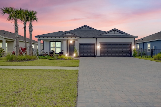 view of front of property featuring a garage and a lawn