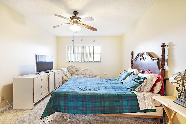 bedroom featuring a textured ceiling, light colored carpet, and ceiling fan