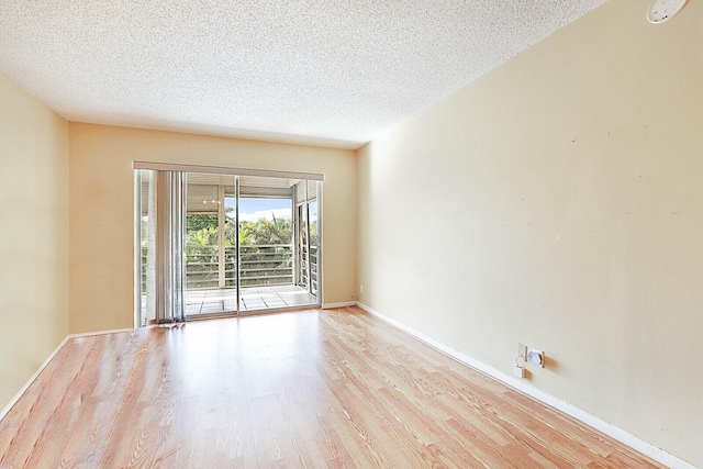 empty room featuring a textured ceiling and light hardwood / wood-style flooring