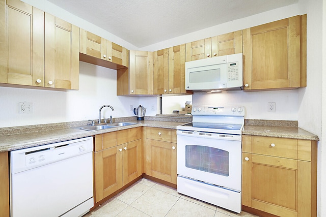 kitchen featuring light tile patterned floors, a textured ceiling, light brown cabinetry, sink, and white appliances