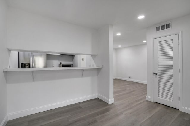 kitchen featuring a breakfast bar, wood-type flooring, and kitchen peninsula