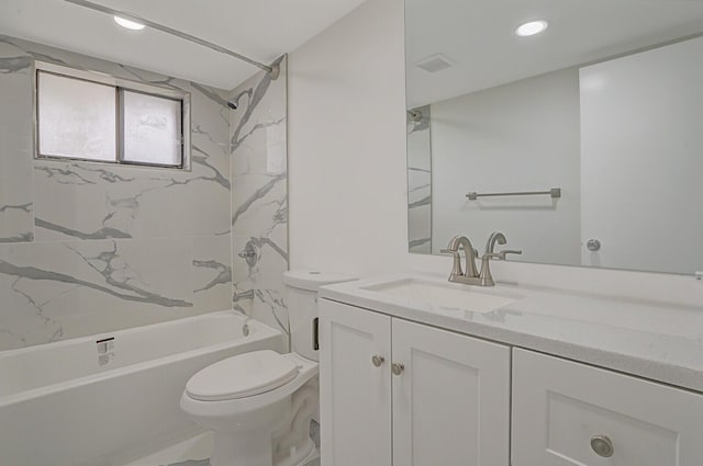 full bathroom featuring vanity, tiled shower / bath, and toilet