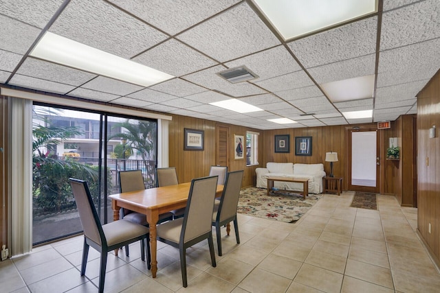 tiled dining area featuring wooden walls