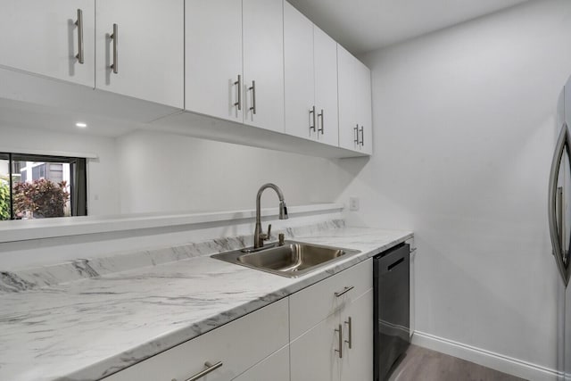 kitchen with dishwasher, sink, white cabinets, and light stone counters