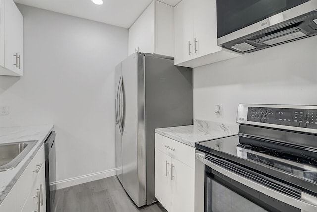 kitchen featuring white cabinetry, light stone counters, and stainless steel appliances