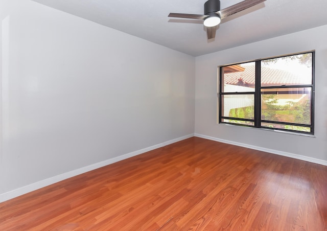 empty room featuring a wealth of natural light, hardwood / wood-style floors, and ceiling fan