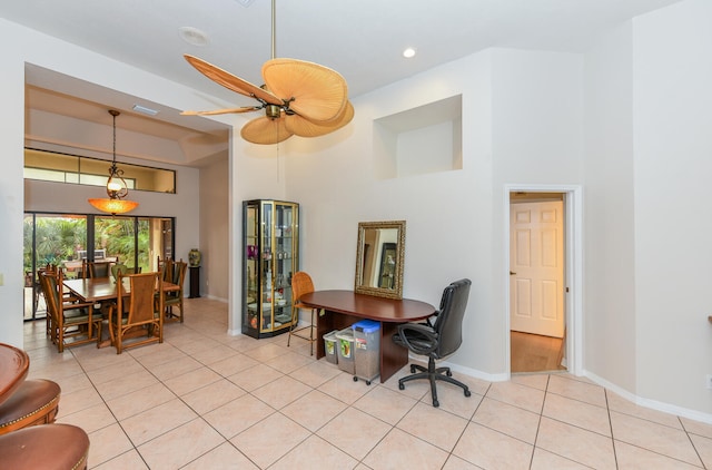 tiled office space with a towering ceiling and ceiling fan