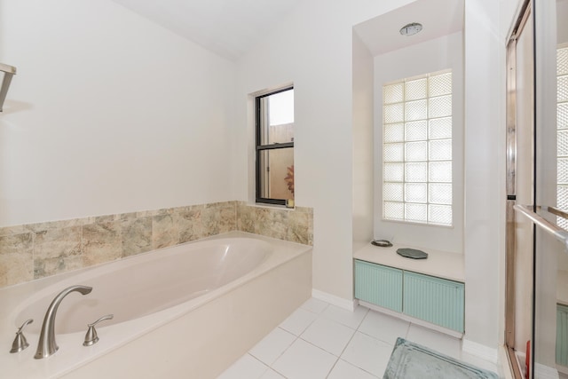 bathroom featuring a tub, a healthy amount of sunlight, and lofted ceiling