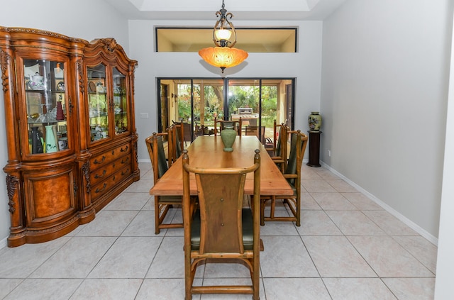 dining room with light tile patterned flooring and a tray ceiling