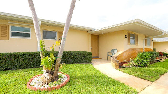 doorway to property with a lawn