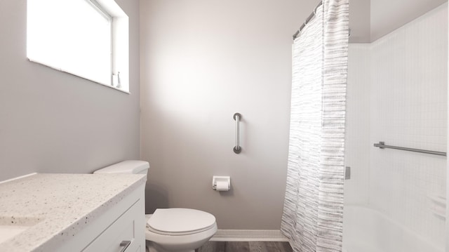 full bathroom featuring vanity, hardwood / wood-style floors, shower / tub combo with curtain, and toilet