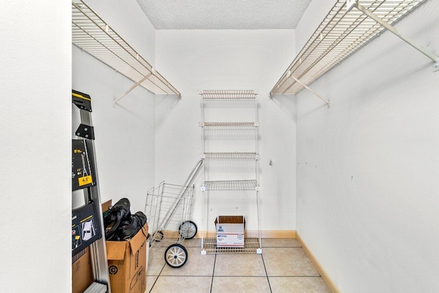 walk in closet with light tile patterned floors