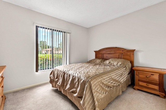 bedroom with a textured ceiling and light colored carpet