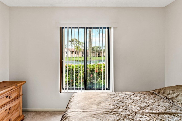 bedroom featuring a textured ceiling and light colored carpet