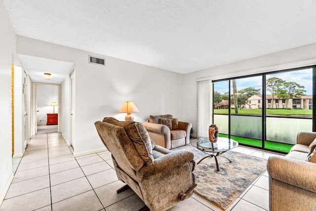 living room featuring a textured ceiling and light tile patterned floors