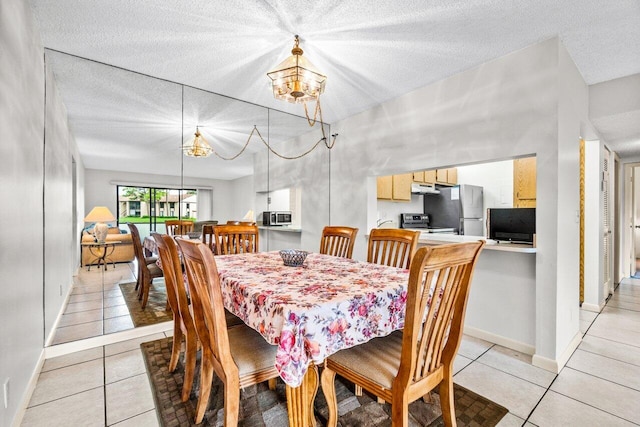 dining room with a notable chandelier, a textured ceiling, and light tile patterned floors