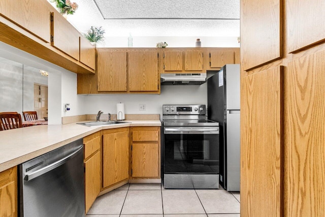 kitchen with light tile patterned flooring, a textured ceiling, stainless steel appliances, and sink