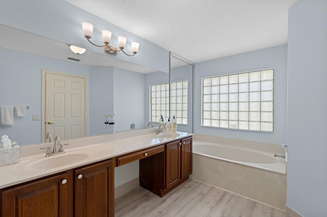 bathroom featuring vanity, a tub, a textured ceiling, and hardwood / wood-style floors