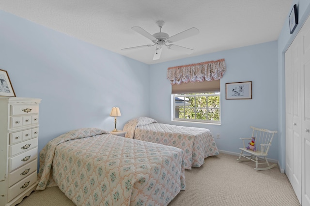 bedroom with a closet, light colored carpet, and ceiling fan