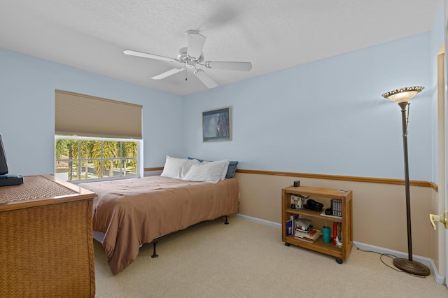 carpeted bedroom featuring a textured ceiling and ceiling fan