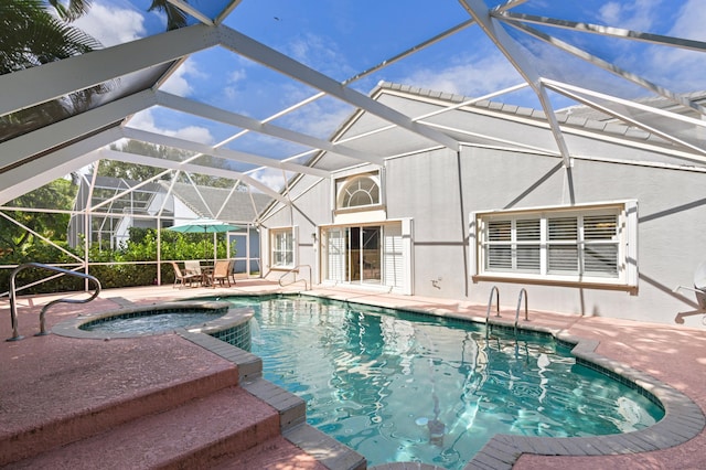 view of pool featuring an in ground hot tub, a patio, and glass enclosure