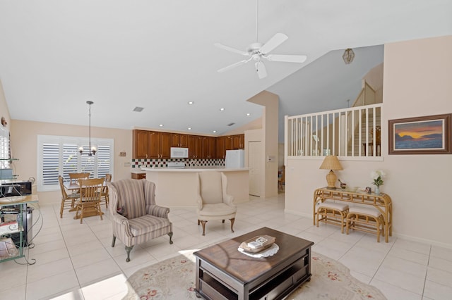 living room featuring light tile patterned flooring, high vaulted ceiling, and ceiling fan with notable chandelier