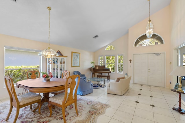 tiled dining area with high vaulted ceiling and an inviting chandelier