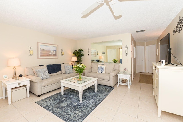 tiled living room featuring a textured ceiling and ceiling fan