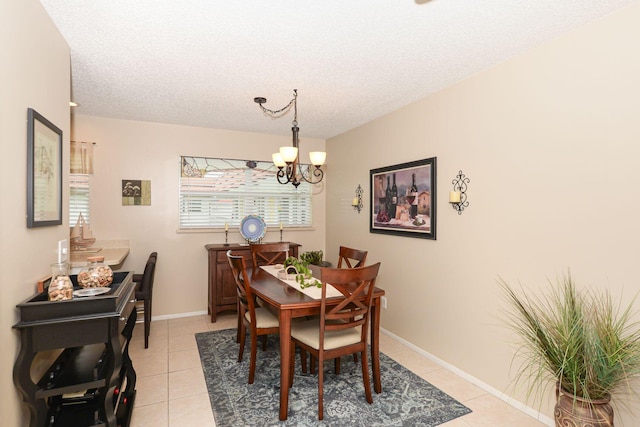 tiled dining space featuring a notable chandelier and a textured ceiling