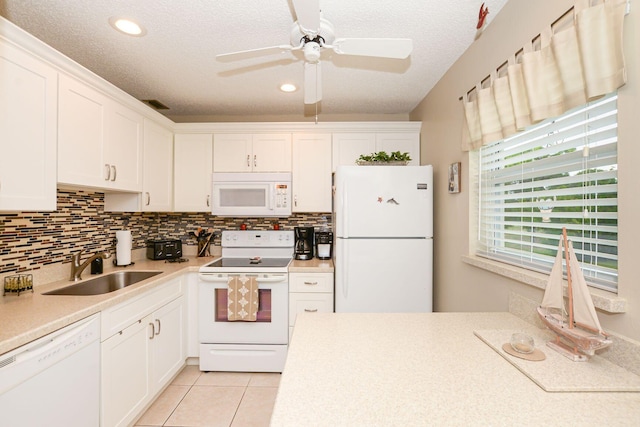 kitchen with sink, white appliances, a textured ceiling, and white cabinets