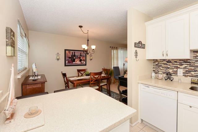 kitchen with white dishwasher, white cabinetry, pendant lighting, and a textured ceiling