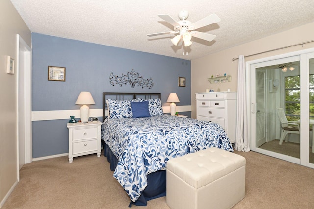 carpeted bedroom featuring access to outside, a textured ceiling, and ceiling fan