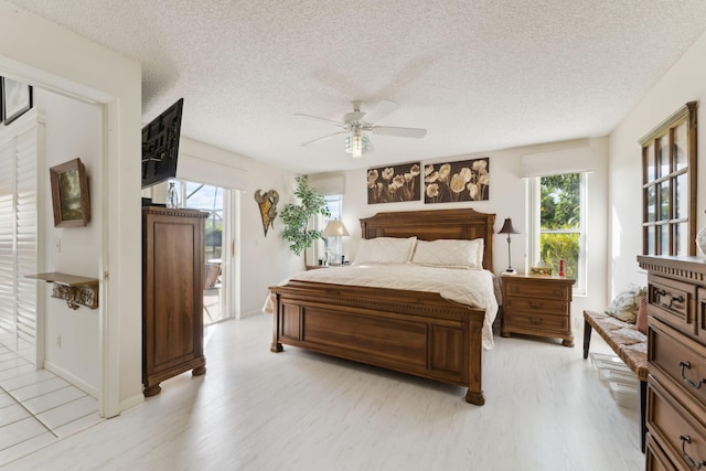 bedroom featuring a textured ceiling, light hardwood / wood-style floors, and ceiling fan