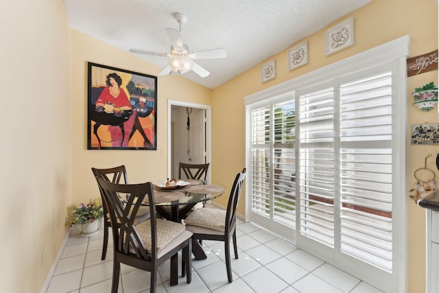 tiled dining room with ceiling fan, lofted ceiling, and a textured ceiling