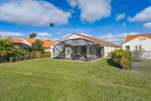 back of house with a yard, a patio, and a lanai