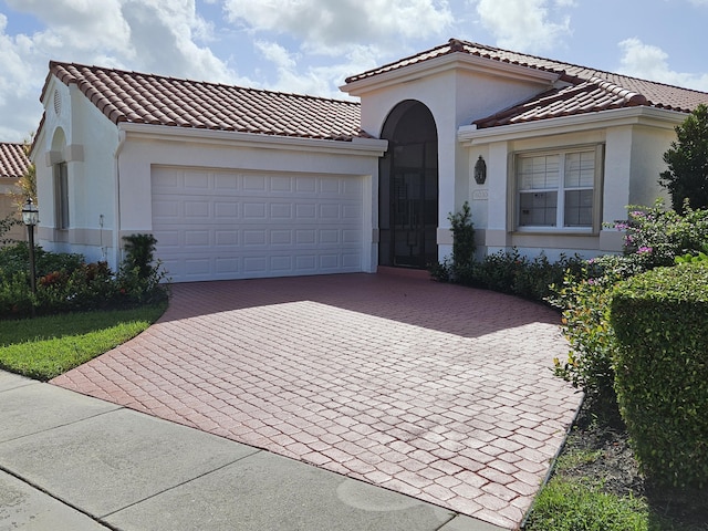 mediterranean / spanish-style home with a garage