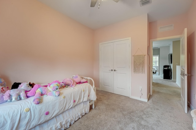 carpeted bedroom featuring ceiling fan and a closet