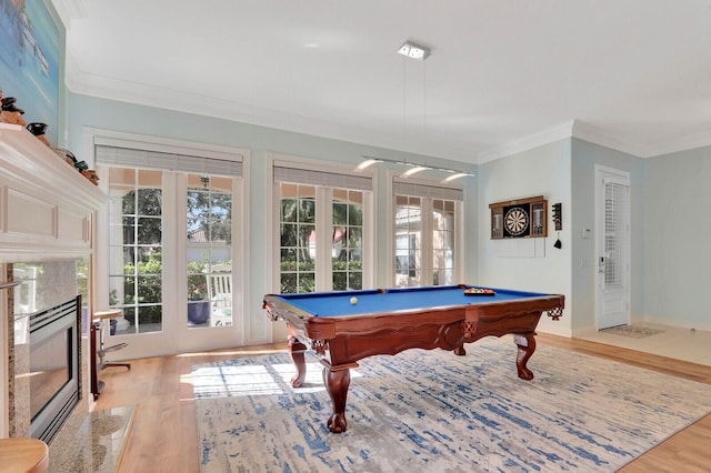 rec room with crown molding, billiards, a fireplace, and light wood-type flooring