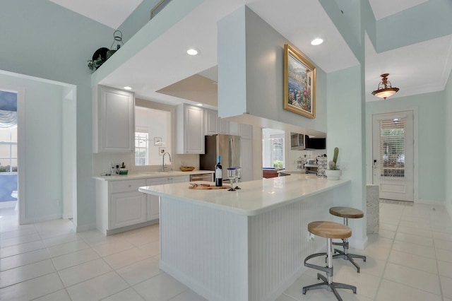 kitchen with white cabinetry, a healthy amount of sunlight, appliances with stainless steel finishes, and kitchen peninsula