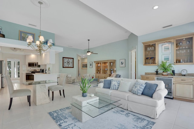 tiled living room featuring beverage cooler and ceiling fan with notable chandelier