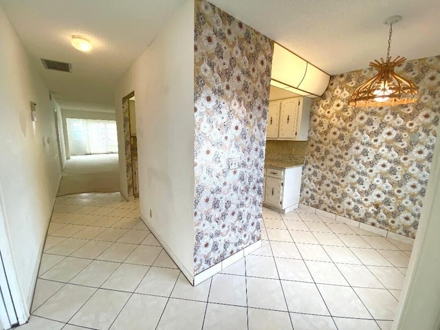 interior space featuring light tile patterned floors and a textured ceiling