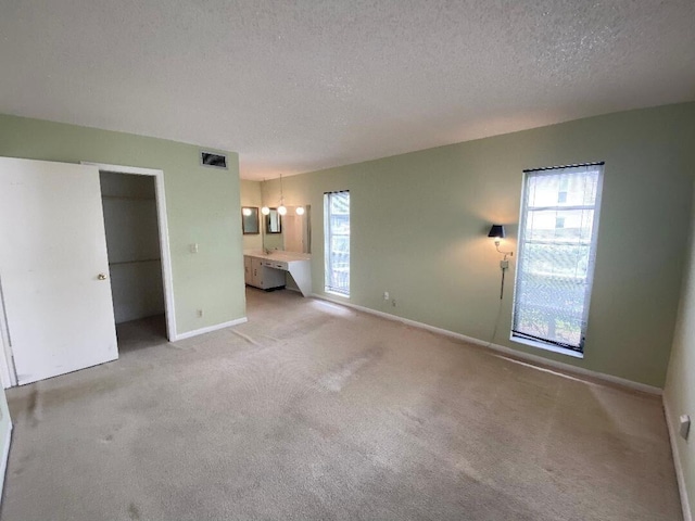 unfurnished bedroom with light colored carpet, a textured ceiling, and a closet