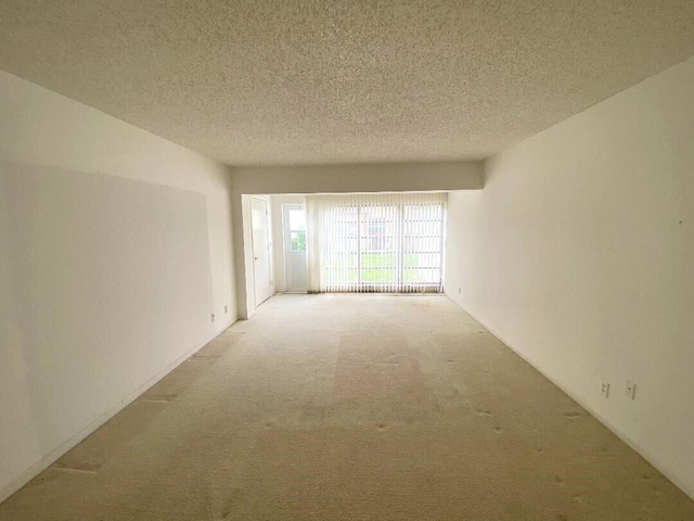 unfurnished room with carpet and a textured ceiling