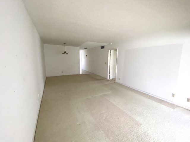 carpeted spare room with a textured ceiling