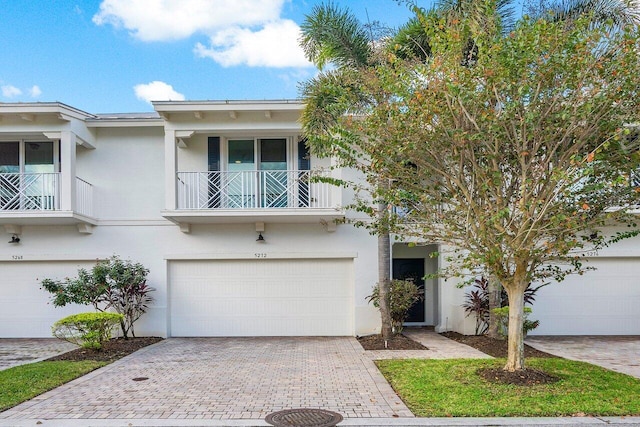 view of property with a balcony and a garage