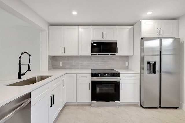 kitchen with tasteful backsplash, light tile patterned floors, white cabinetry, sink, and stainless steel appliances