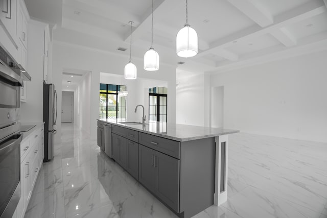 kitchen with white cabinetry, coffered ceiling, pendant lighting, light stone counters, and a kitchen island with sink