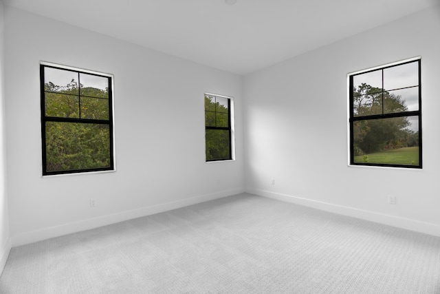 carpeted spare room featuring plenty of natural light